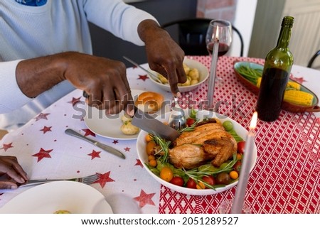 Hands of african american senior man eating christms meal at home. retirement lifestyle and christmas festivities, celebrating at home.