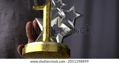 A 3D rendering of a first place golden award and male hand holding on a blurry background