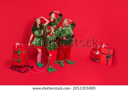 Full length photo of santa helpers people hand head look empty space with sleigh giftboxes wear new year costumes isolated on red background