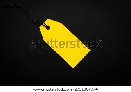 A yellow blank price tag on black background for shopping and discount on Black Friday concept.