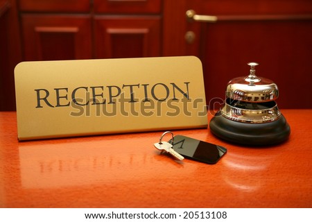 Close up of key and bell on wooden reception desk