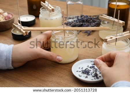 Woman making aromatic candles at wooden table, closeup Royalty-Free Stock Photo #2051313728