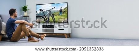 Man Watching Connected TV Screen In Living Room Royalty-Free Stock Photo #2051352836