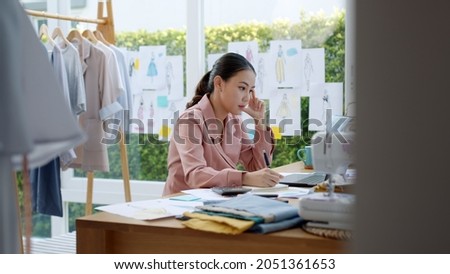 Woman seller SME retail store owner work hard worry stress in bad news on laptop at home office desk. Asian people crisis tailor job issue feel tired tough and upset in cash money loss or loan debt. Royalty-Free Stock Photo #2051361653