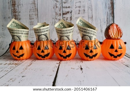 Dollar money on pumpkin bucket on old wood table