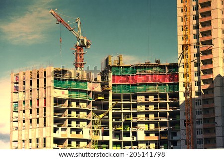 construction site and block of flats building with crane, vintage colors