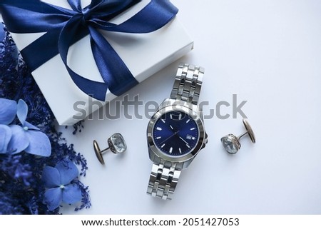 gift concept for men. Men's Accessories. blue flowers, gift box with blue bow, mens watch and cufflinks isolated on white background. father's day 