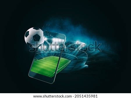 Watch a live sports event on your mobile device. Betting on football matches Royalty-Free Stock Photo #2051435981