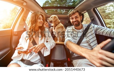 The whole family is driving for the weekend. Mom and Dad with their daughter and a Labrador dog are sitting in the car. Leisure, travel, tourism. Royalty-Free Stock Photo #2051440673