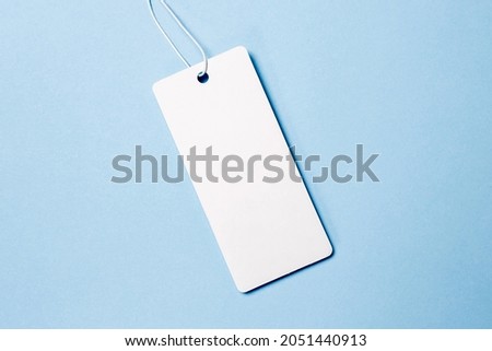 white tags, sale tag on blue background. Mockup, copy space for text, top view