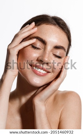 Vertical portrait of beautiful female model touching her glowing, moisturized perfect skin, close eyes and smiling happy, after shower concept, white background Royalty-Free Stock Photo #2051460932