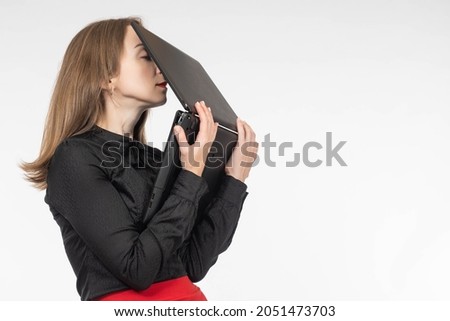 Tired experienced worker. woman is exhausted. Tired girl on white background. Burnout metaphor at work. woman manager sends laptop to her face. Workplace stress concept. Businesswoman is under stress