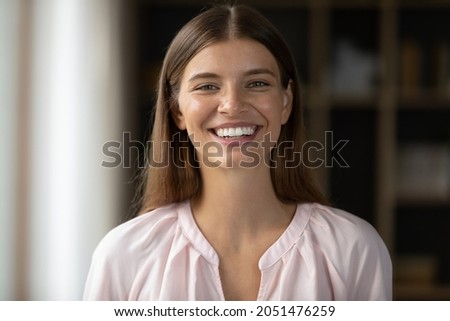 Happy beautiful young Caucasian woman with perfect white teeth looking at camera, laughing. Millennial teen student girl in casual female home head shot portrait. Dentistry, beauty care concept