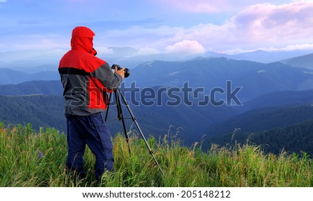 Photographer in twilight. Mountain landscape