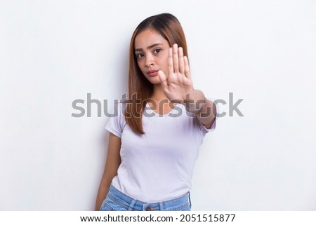 beautiful young woman with open hand doing stop sign with serious expression defense gesture isolated on white background
