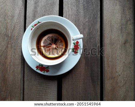 Cup of coffee and orange slices placed on wooden table