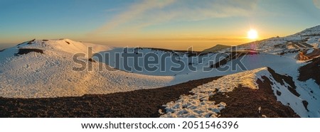 Snow covered landscape on Mount Etna volcano at sunset, in Sicily, Italy, a popular hiking and skiing holiday destination