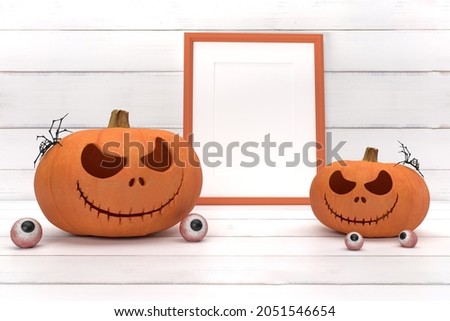 Group spooky halloween pumpkin, Jack O Lantern, with an evil face and eyes , ghost spider, photo frame and eyeball on a white wood background.