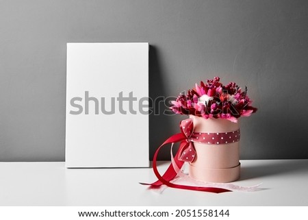 Blank canvas mockup with dried flowers on gray wall background