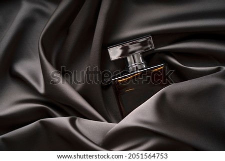 Men's perfume bottle in satin cloth draperies. Royalty-Free Stock Photo #2051564753