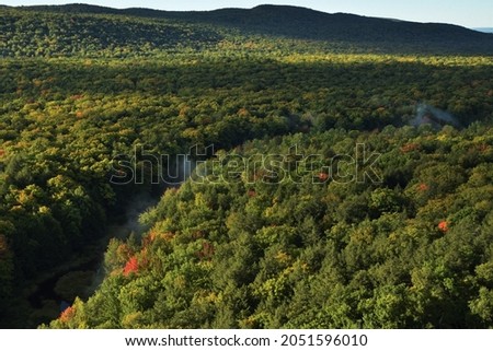 Mist rising from a small river winding through the Porcupine Mountains in Michigan during an early fall morning.