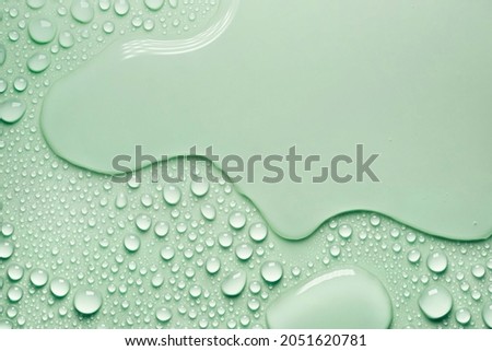 Cosmetic moisturizing liquid drops on gray mint pastel background. Toner or lotion. Hyaluronic serum Royalty-Free Stock Photo #2051620781