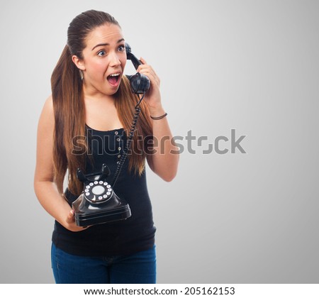 pretty young woman surprised talking on telephone