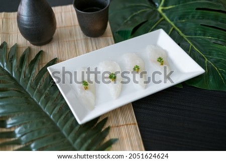 Sashimi on white plate in Japanese restaurant. Served sushi in the restaurant. Japanese traditional food. Raw white fish. Photo for the menu. 