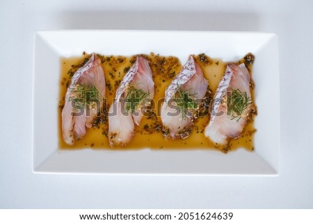 Sea bass sashimi with the sauce on white plate on white background. Isolated on white. Japanese restaurant. Japanese traditional food. Raw fish.