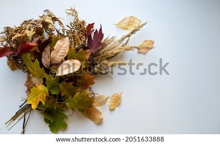 Autumn bouquet of yellow and orange flowers, red berries and maple leaves
