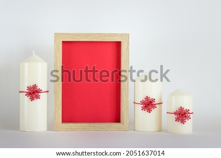 Christmas, New Year mockup, template with blank frame with red background and three white candles and red snowflakes on white background.
