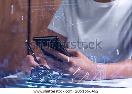 Businesswoman is signing the contract to create a software to present it at start up conference and gain investments for innovative service. Checking the details at smartphone. Hologram tech graphs.