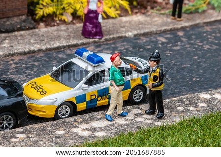 BABBACOMBE, TORQUAY, ENGLAND- 26 June 2021: Model police speaking to a man at Babbacombe Model Village in Torquay