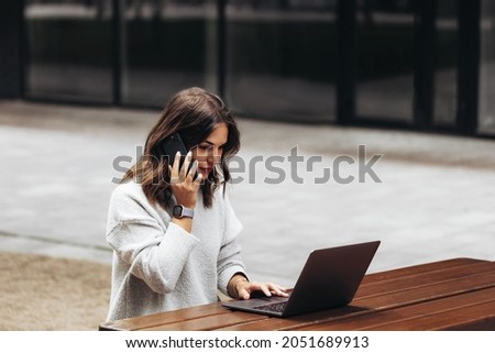 Portrait of a Successful Business woman working with MacBook Pro in outside  Royalty-Free Stock Photo #2051689913