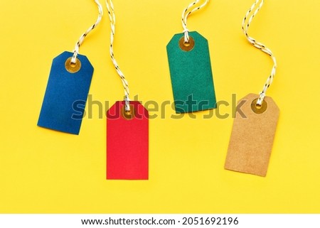 Colorful sale tags on a bright yellow background. Sale and Black Friday concept. Top view, copy space for text