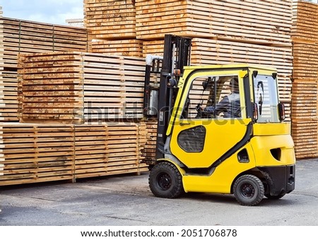 Forklift loads lumber into stacks at the finished product warehouse Royalty-Free Stock Photo #2051706878
