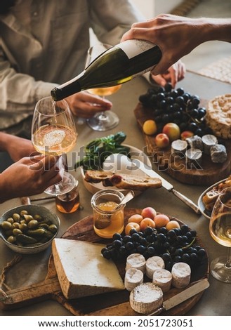Human hand pouring white orange or rose wine from bottle Royalty-Free Stock Photo #2051723051
