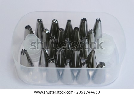 stainless steel cake tools in plastic container. tools for decorating cakes with cream.