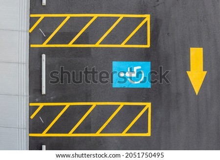 overheasd view of handicapped parking stall with directional arrow
