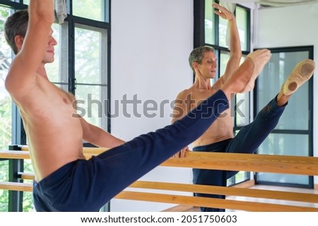 Confidence Caucasian male ballet dancer practicing ballet dance alone in studio room. Handsome man athletic dancing classic ballet showing performance body exercise stretching and strength muscle.