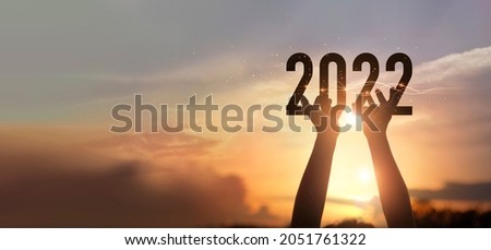 Hands holding of new year 2022 silhouette against on the sunset background, Happy New Year concept. 
