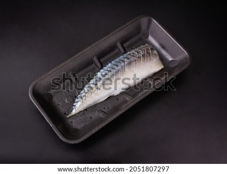 Half fresh tuna sliced on black foam tray isolated on a black background, tuna for sale, Top view.