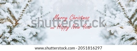 Christmas festive background text Merry Christmas and Happy New Year. Fluffy spruce branches in the snow with sparkles