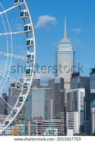 Ferris wheel and skyscraper in downtown district of Hong Kong city