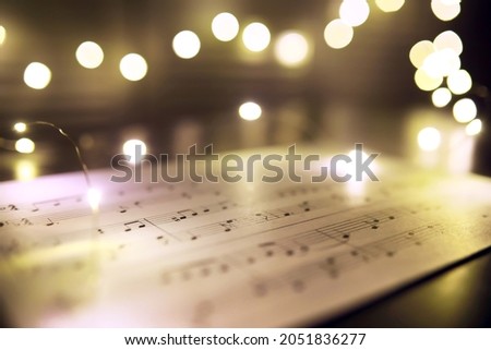 Old sheet with Christmas music notes as background, bokeh effect
 Royalty-Free Stock Photo #2051836277