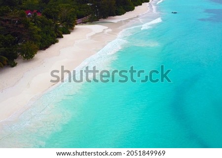 Aerial view of a beautiful beach with emerald water and white sand in the Seychelles.