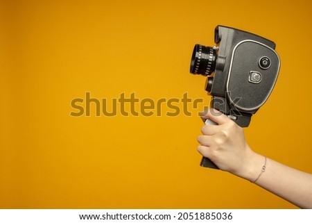 woman Hand holding small video old retro black camera 8 mm isolated on white background Royalty-Free Stock Photo #2051885036