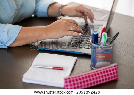 
One working day, laptop, pink pencil case, pink glasses, wooden table. White and blue colors.