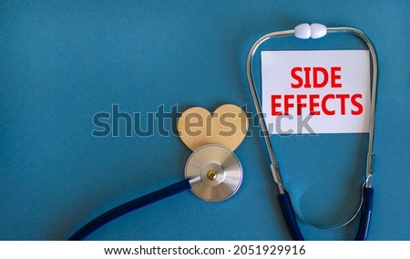 Side effects symbol. White card with words Side effects, beautiful blue background, wooden heart and stethoscope. Medical and side effects concept. Royalty-Free Stock Photo #2051929916