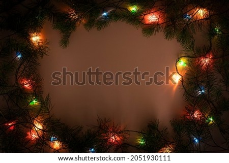 Christmas lights frame on dark background. Holiday shiny garland border top view. Xmas tree decorations, winter holidays illumination